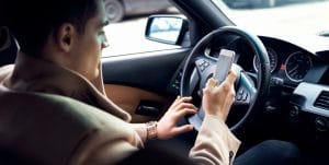 Man texting behind the wheel of a car