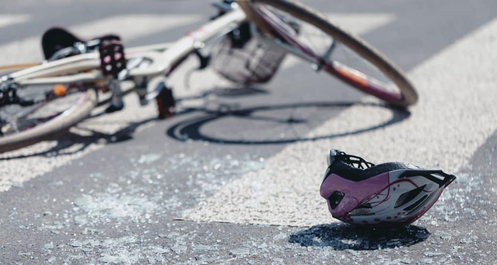 Helmet and bicycle on pedestrian crossing after traffic accident