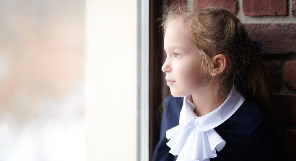 Young girl looking out a window